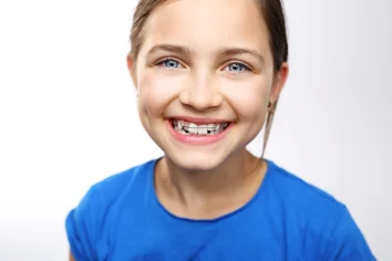 Lachendes Mädchen mit schiefen Zähnen ist stolz auf ihre neue Zahnspange.